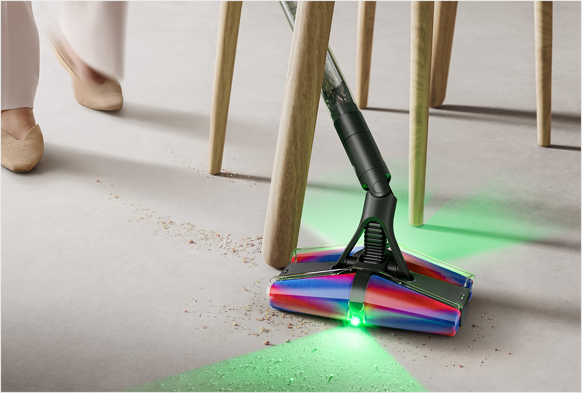 Model using the Dyson PencilVac cleaner around a chair with the illumination lights.