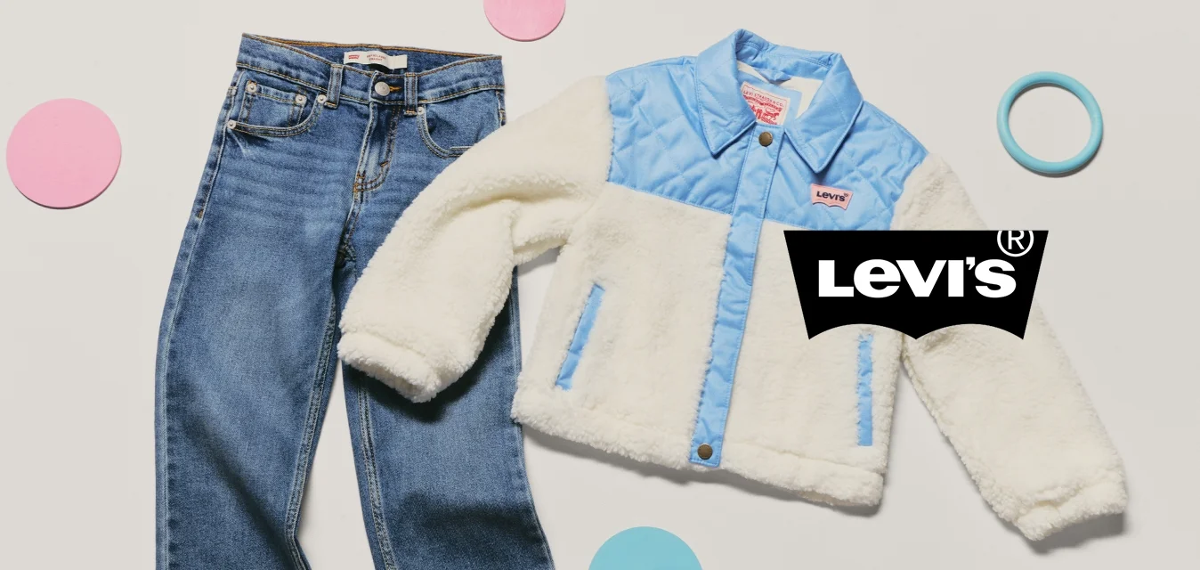 Jeans in denim blu per giovani abbinati a una giacca di pile crema e azzurro, circondati da forme circolari rosa e blu su uno sfondo bianco.