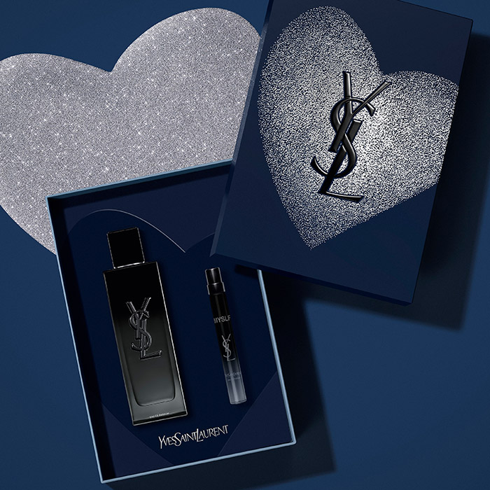 Un set regalo di profumo YSL in una scatola blu scuro con un cuore argento glitterato.
