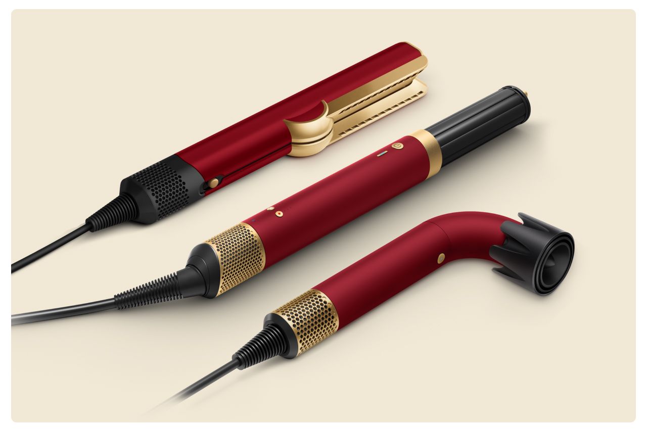 A collection of devices from the Dyson Beauty range in Red velvet and gold.
