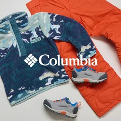 Pullover in pile con motivo blu e bianco, pantaloni isolanti arancioni brillanti e scarpe da trekking grigie con accenti blu e arancioni disposte su uno sfondo chiaro.