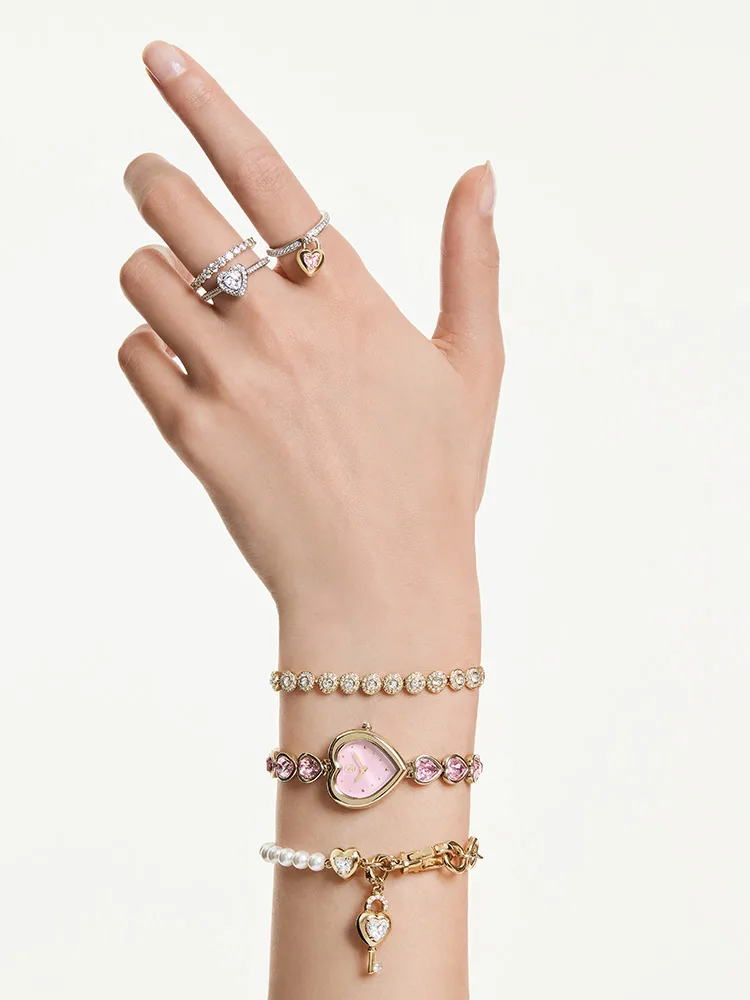 Modella che indossa un orologio rosa con quadrante a forma di cuore