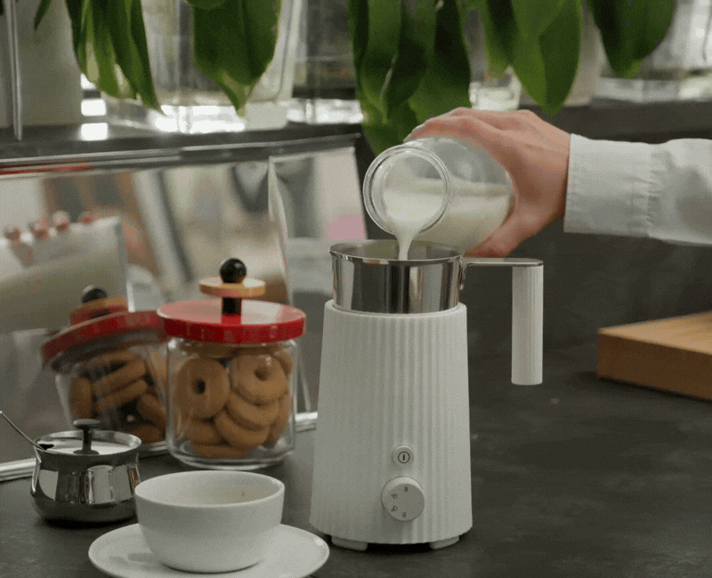an image of a table with a pitcher, a cup of milk, a cookie and a cookie