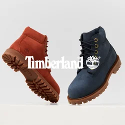 Stivali marroni e blu navy con texture in camoscio e suole in gomma, dotati di occhielli metallici e design con lacci, orientati diagonalmente su un piedistallo.