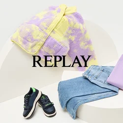 Giacca pelosa viola e gialla, felpa lavanda, jeans blu e sneakers navy con dettagli verdi, disposti su un'esposizione curva bianca.