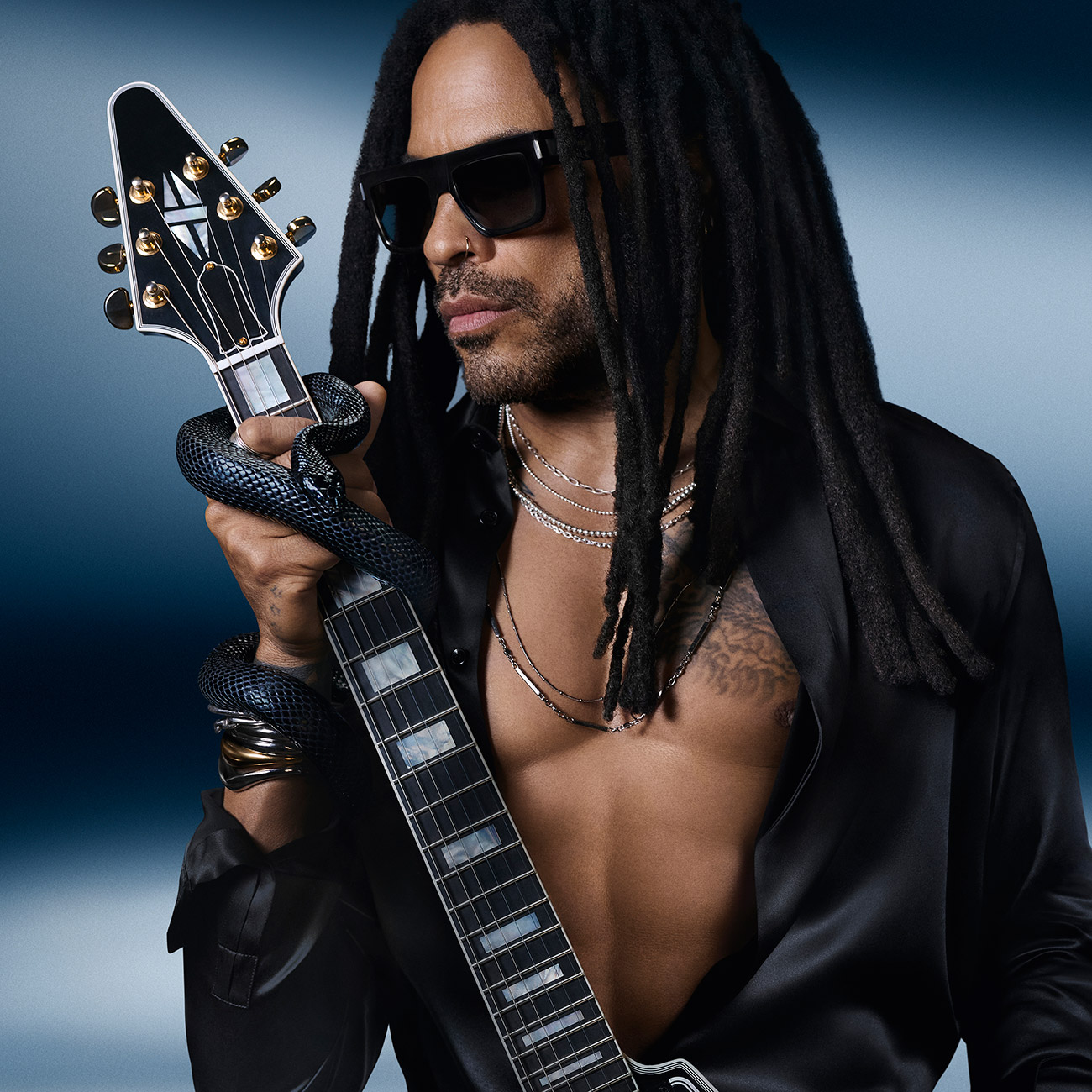 Lenny Kravitz posa con una chitarra nera avvolta da un serpente.