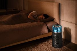 Dyson HushJet Purifier Compact acceso in una camera vicino a un uomo che dorme.