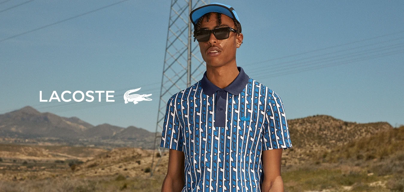 Polo a righe blu e bianche con colletto blu scuro, maniche corte e bottoni, abbinato a pantaloni corti neri e occhiali da sole.