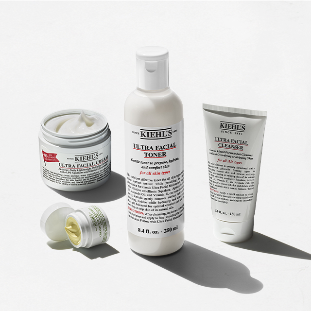 Set skincare Kiehl&rsquo;s composto da Ultra Facial Cleanser, Ultra Facial Toner, Ultra Facial Cream formato 28 ml e Creamy Eye Treatment with Avocado 14 ml, disposti su sfondo neutro.