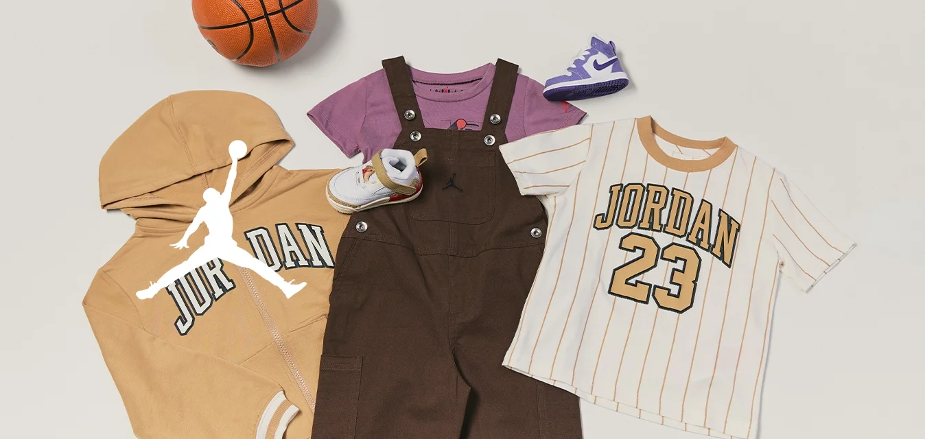 Completo da basket per bambini con felpa con cappuccio Jordan color pelle, maglietta viola, salopette marrone, T-shirt a righe Jordan 23, mini pallone da basket e piccole scarpe da ginnastica.