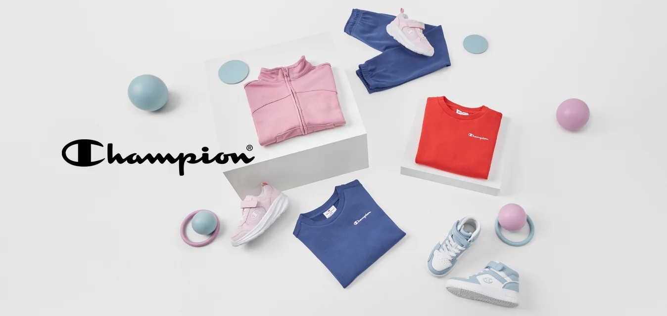 Quattro capi di abbigliamento: una giacca rosa con zip, una maglietta rossa, una maglietta blu e pantaloni blu scuro. Due paia di scarpe e palloni colorati nelle vicinanze.