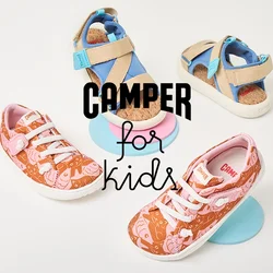 Due paia di scarpe per bambini su piattaforme circolari: un paio arancione con motivi rosa e lacci bianchi, e sandali beige con accenti blu.