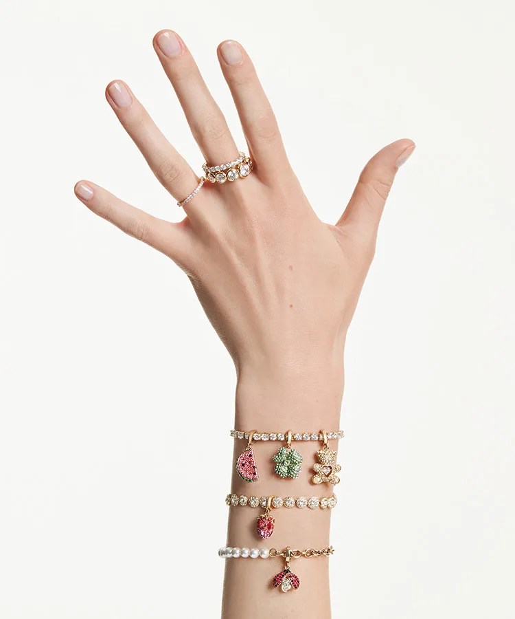 Mano di modella con al polso bracciali con charm