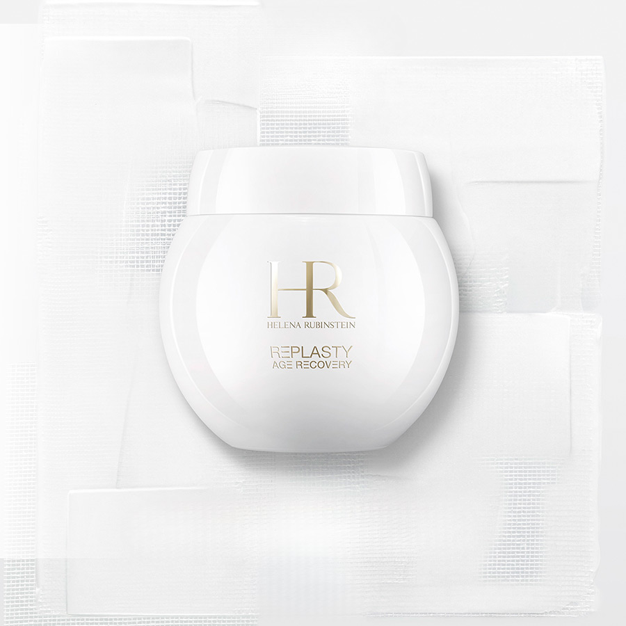 Vasetto di crema Age Recovery Day posato sulla texture bendaggio, sfondo bianco.