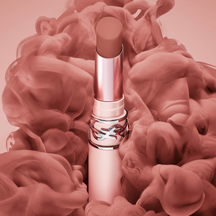 Un rossetto YSL circondato da fumo rosa artistico.