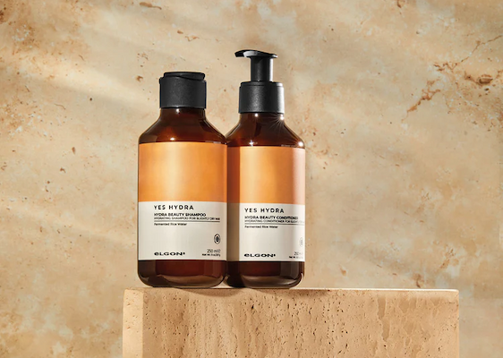 an image of a bottle of liquid sitting on a bed of petals