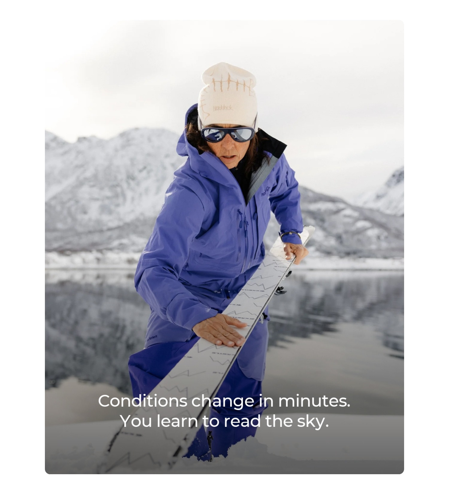 an image of a woman in a blue jacket holding a snowboard