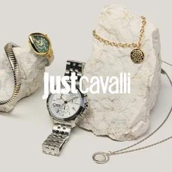 Due esposizioni in pietra con gioielli: braccialetti d'oro e d'argento, un orologio d'argento con quadrante bianco, una collana d'oro e un ciondolo d'argento con catena.