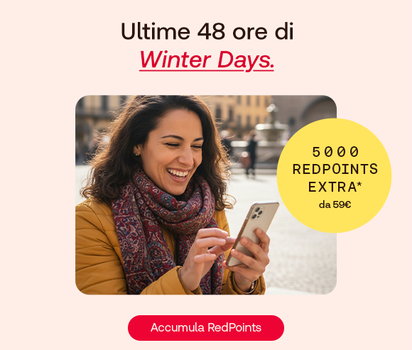 Donna sorridente con cappotto e sciarpa invernale guarda il suo smartphone all’aperto. In alto il testo: “Ultime 48 ore di Winter Days”, con “Winter Days” evidenziato in rosso corsivo e sottolineato. A destra un bollino giallo indica: “5000 RedPoints extra da 59€”. In basso un pulsante rosso: “Accumula RedPoints”. Donna sorridente con cappotto e sciarpa invernale guarda il suo smartphone all’aperto. In alto il testo: “Ultime 48 ore di Winter Days”, con “Winter Days” evidenziato in rosso corsivo e sottolineato. A destra un bollino giallo indica: “5000 RedPoints extra da 59€”. In basso un pulsante rosso: “Accumula RedPoints”.