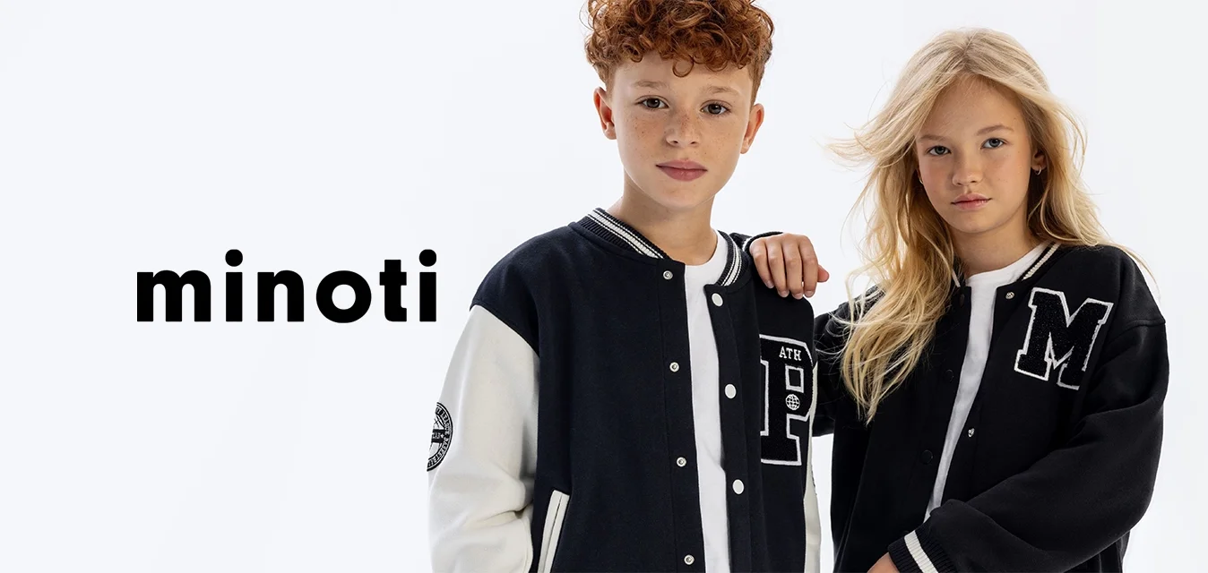 Giubbotti varsity in bianco e nero con toppe a lettere. Morbida texture, chiusura a bottoni e colletti a coste a righe. I modelli indossano t-shirt bianche sotto.