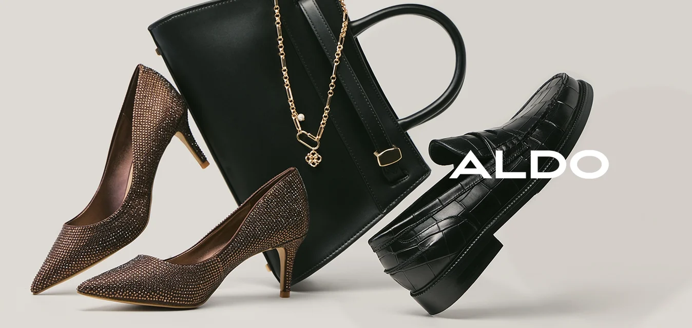 Coppia di décolleté marroni, borsa nera in pelle con catena dorata e mocassini neri con motivo a coccodrillo su sfondo neutro.