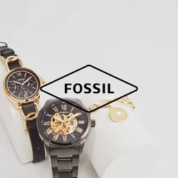 Due orologi Fossil esposti su un supporto bianco. A sinistra: oro con quadrante nero, cinturino in pelle. A destra: cassa in metallo nero, movimento visibile, dettagli dorati.