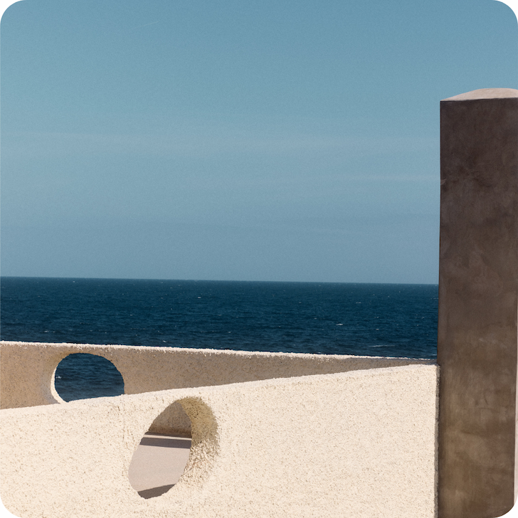 an image of a person sitting on a bench looking out at the ocean