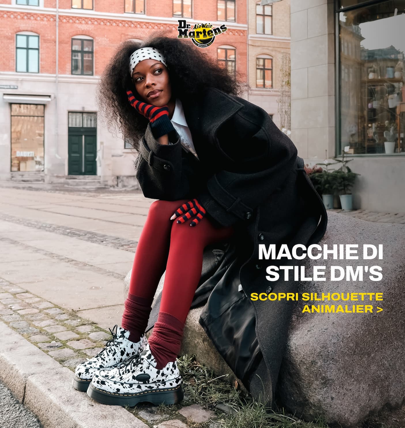 an image of a woman sitting on a rock in a city