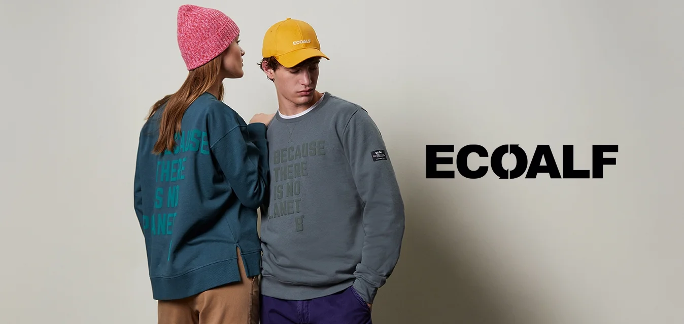 Due maglioni: uno color teal con grande scritta verde, l'altro grigio con scritta verde. Un berretto lavorato a maglia rosa e un cappello giallo completano gli outfit.