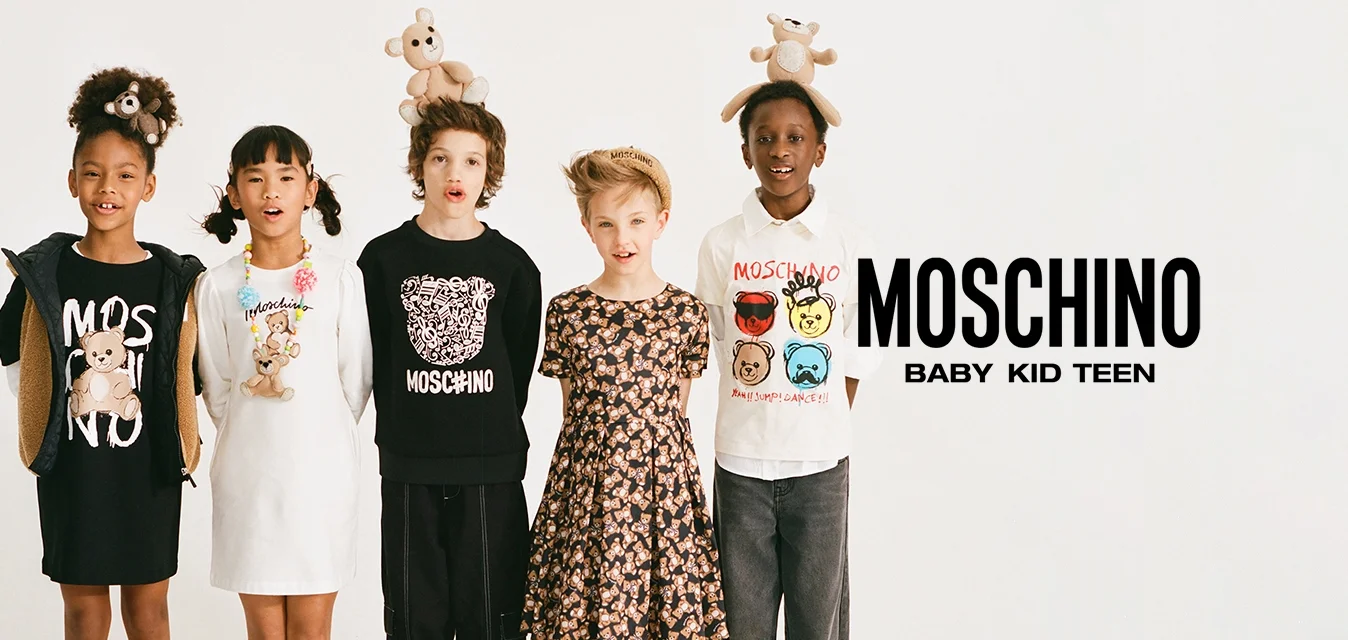 Cinque bambini vestiti con abiti Moschino stanno in fila, ognuno con un orsacchiotto come accessorio sulla testa o sul vestito.