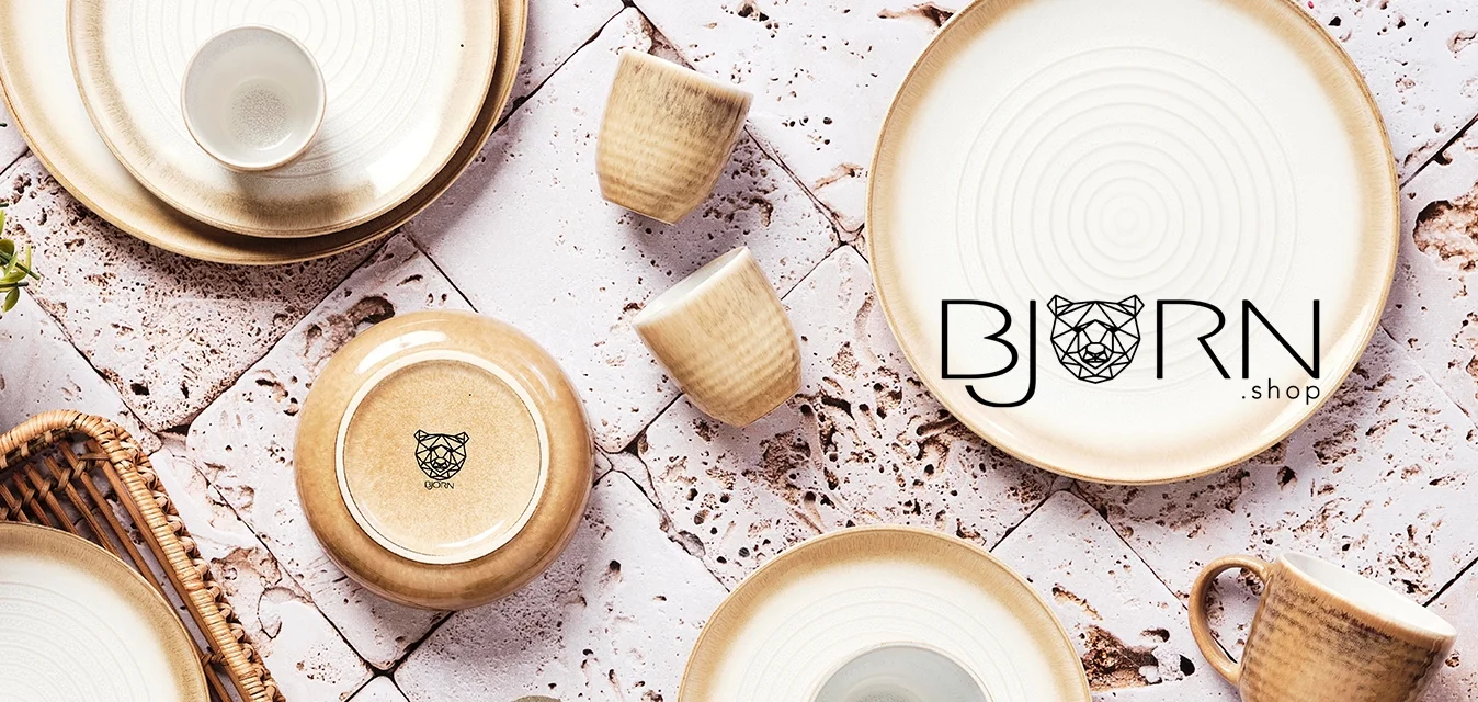 Set di stoviglie in ceramica con colori crema e marrone chiaro, motivi circolari, superfici testurizzate e un vassoio di legno con una pianta.