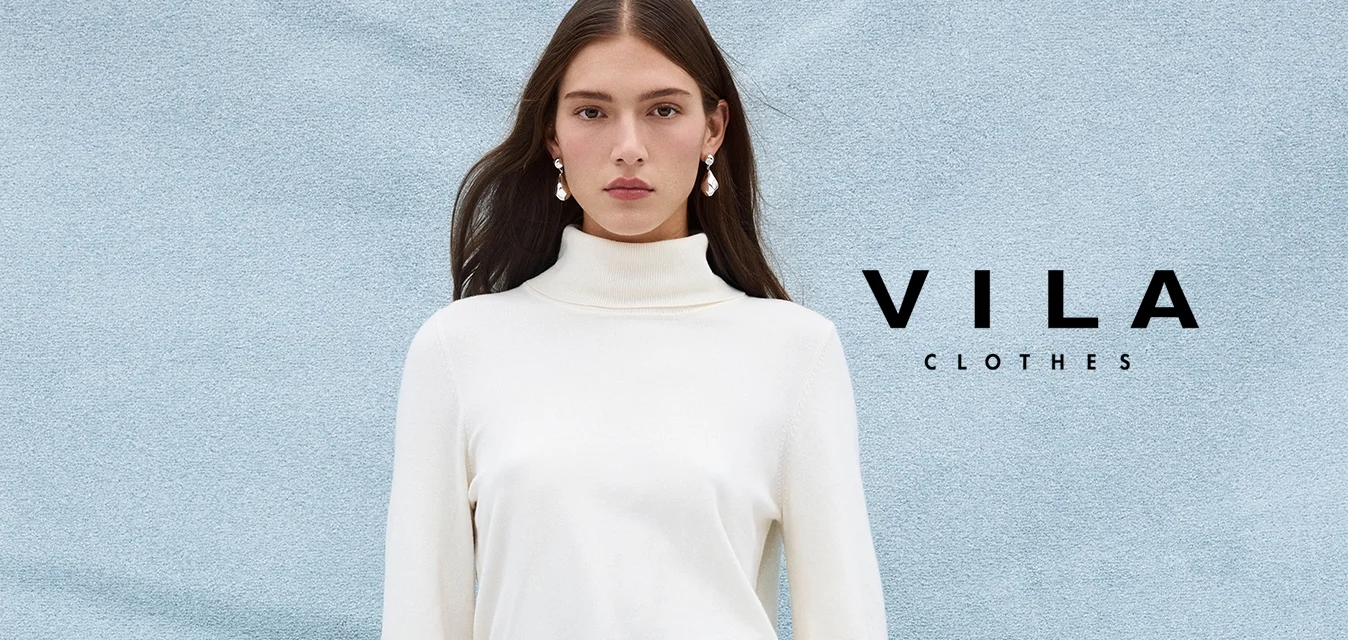 Vestito a maglia bianco a collo alto con maniche lunghe e cintura abbinata. Abbinato a collant grigi e stivali beige al ginocchio con tacco.