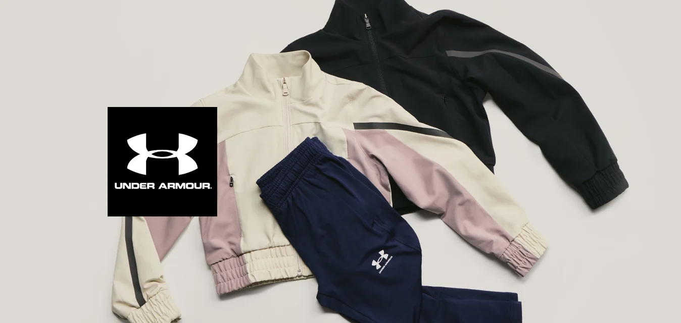 Due giacche con cerniera—una beige con strisce rosa e nere, una nera—distese su uno sfondo chiaro insieme a un paio di pantaloni sportivi blu navy.