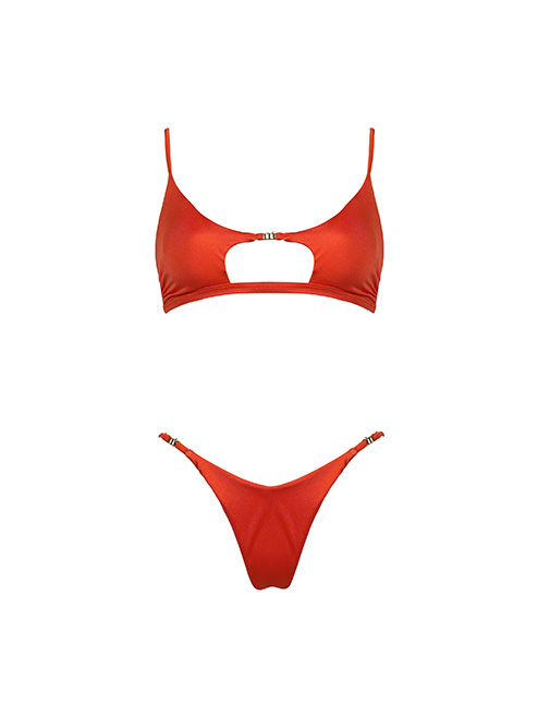 Red women’s two-piece bikini set with cut-out underbust top and high-cut V thong bottoms featuring gold ring accents, isolated on white