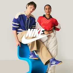 Due giovani adulti in abiti casual posano; uno è seduto su una sedia moderna blu, l'altro sta in piedi con una mano in tasca contro uno sfondo semplice.