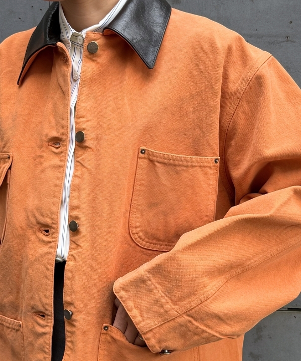an image of a man wearing an orange jacket and black pants