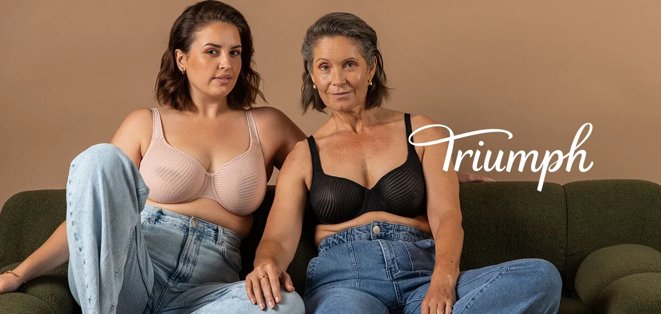 Due persone sedute su un divano verde oliva. Una indossa un reggiseno beige a coste; l'altra, un reggiseno nero con texture. Entrambe in jeans a vita alta.