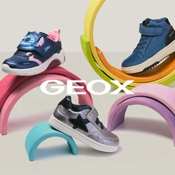 Quattro scarpe da ginnastica colorate per bambini esposte su supporti a forma di arcobaleno pastello, su uno sfondo chiaro.