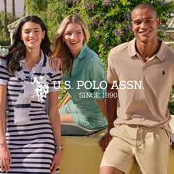 Cinque giovani adulti in abbigliamento estivo casual sorridono e posano accanto a un'auto vintage gialla, con palme e montagne sullo sfondo.