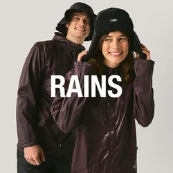 Due persone con giacche antipioggia viola scuro e cappelli neri sorridono davanti a uno sfondo chiaro e uniforme.