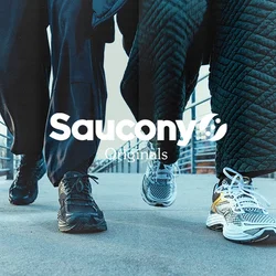 Due persone che camminano su un ponte all'aperto, indossando sneakers e abbigliamento scuro, con parapetti in metallo su entrambi i lati.