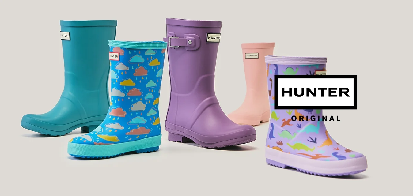 Cinque stivali da pioggia colorati in blu, viola, rosa e con motivi decorativi disposti in una linea sfalsata su uno sfondo semplice.