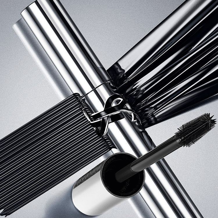 Tubes de mascara YSL argent&eacute;s et brosse avec des traits de mascara noir.