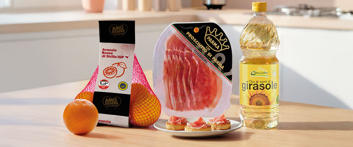 Sicilian oranges in net, packaged Parma prosciutto and sunflower oil bottle on kitchen counter with prosciutto crostini