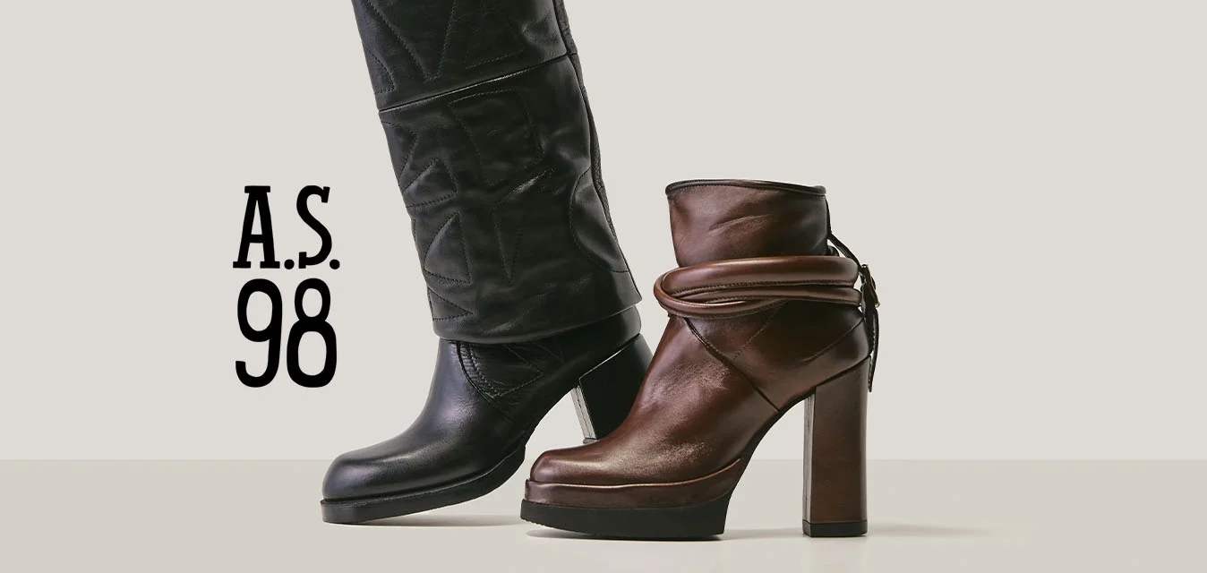 Stivale alto in pelle nera con design strutturato accanto a uno stivaletto con tacco di media altezza in pelle marrone con dettaglio a cinturino avvolgente.