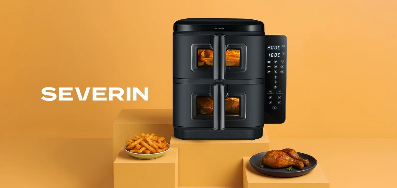 Friggitrice ad aria nera con due scomparti, controlli digitali sul lato, posizionata su uno sfondo arancione chiaro, con patatine e pollo nei piatti.