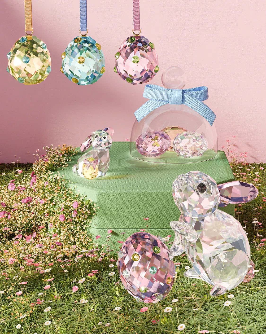 Un gruppo di piccoli soggetti in cristallo Swarovski colorato su una scatola ottagonale rosa.