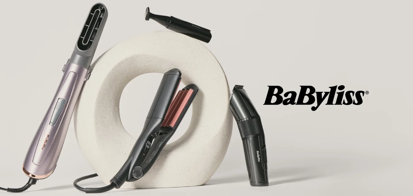 Due strumenti elettrici per lo styling dei capelli, una piastra e una spazzola riscaldata, disposti attorno a una scultura circolare bianca su uno sfondo chiaro.