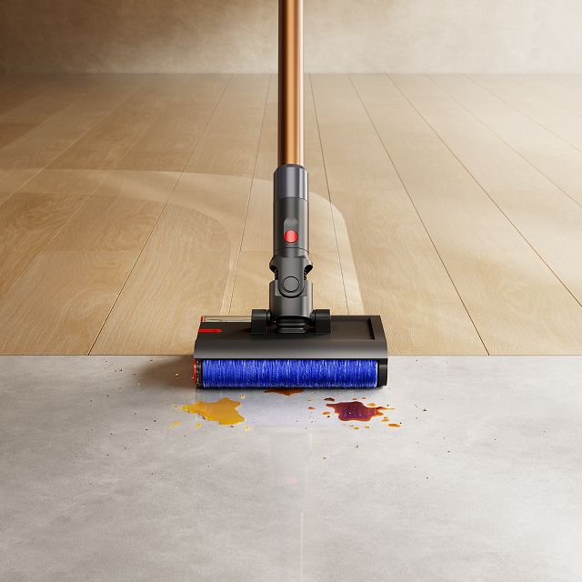 Close-up of the Dyson PencilWash cleaner head as it cleans a spill between hard floor types.