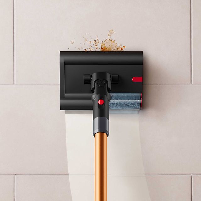 Close-up of the Dyson PencilWash cleaner head as it cleans a spill on a tiled floor.